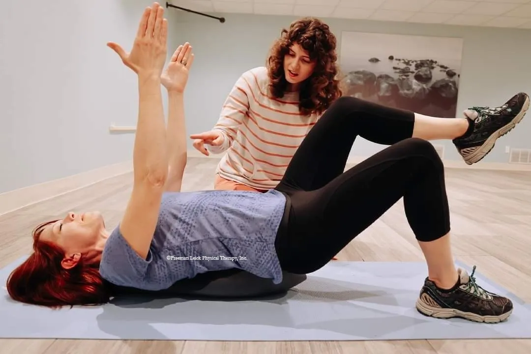 Patient lying on an Oov device with arms raised during a session at Freeman Leick Physical Therapy